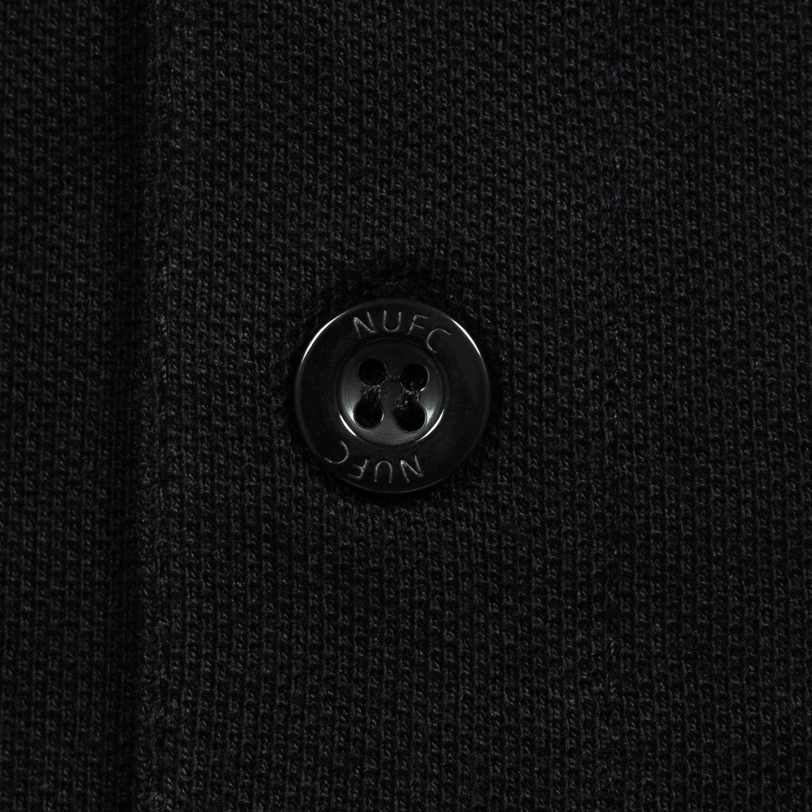 Newcastle Utd adults polo shirt in black with NUFC badge and text to chest.
