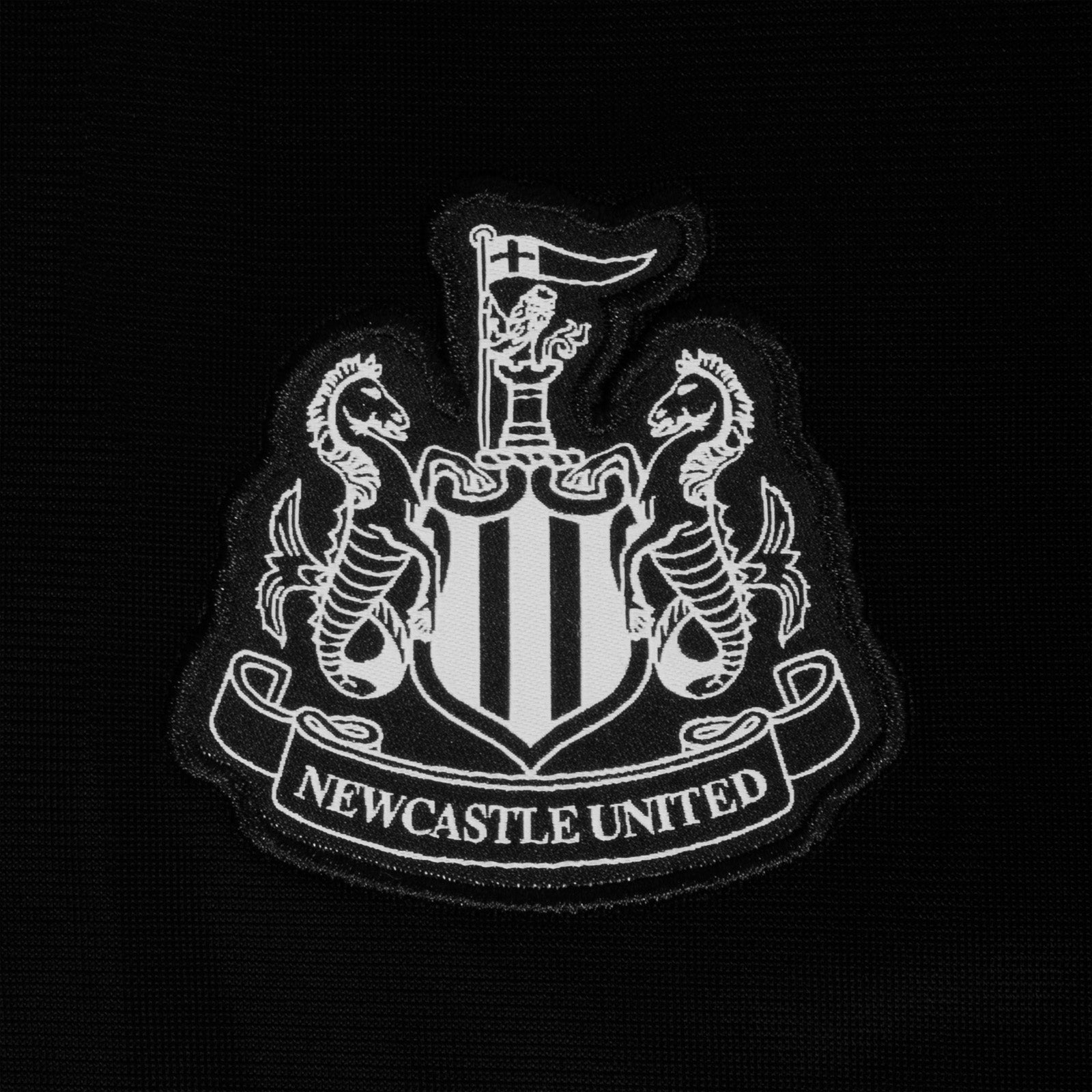 Newcastle United kids taped tracksuit in black with club crest and text to both top & pants