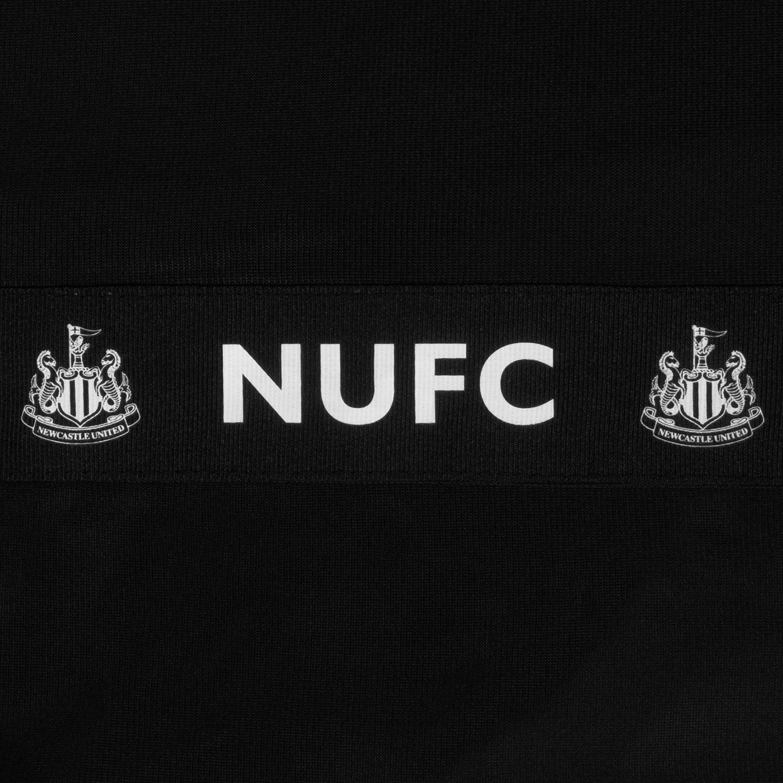 Newcastle United kids taped tracksuit in black with club crest and text to both top & pants