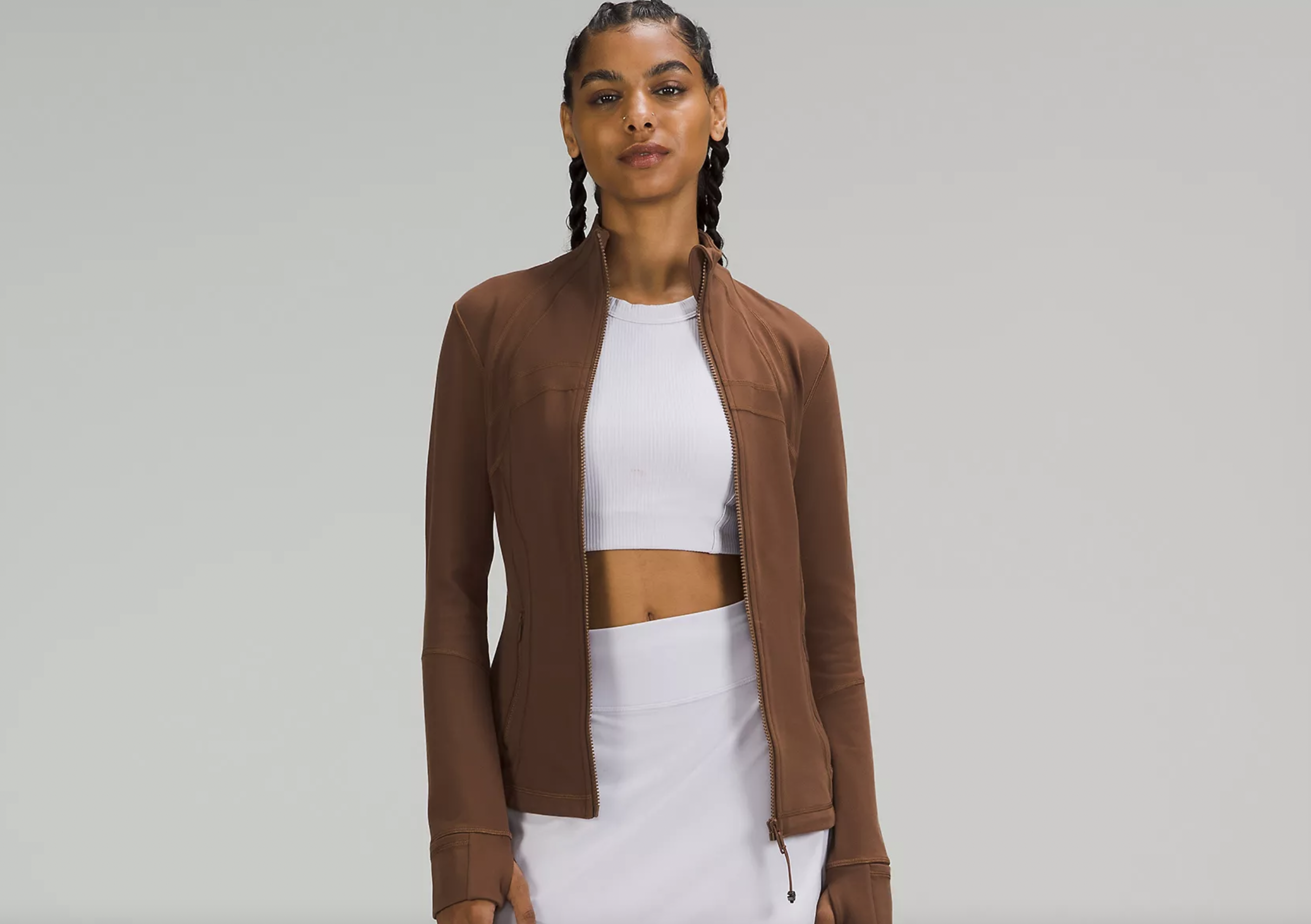 Woman wearing white tank and brown jacket