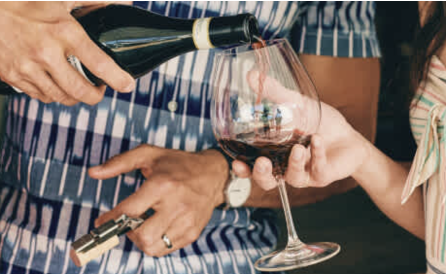 person pouring wine into glass