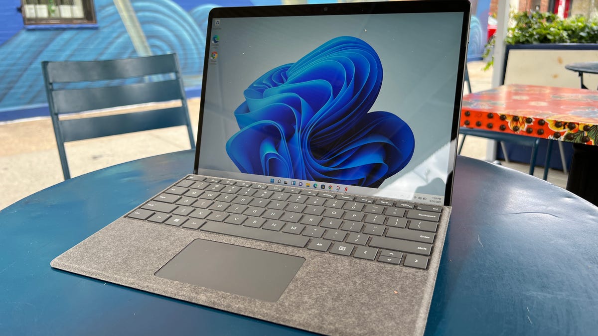 A Microsoft Surface Pro 8 sitting on a blue table outside.