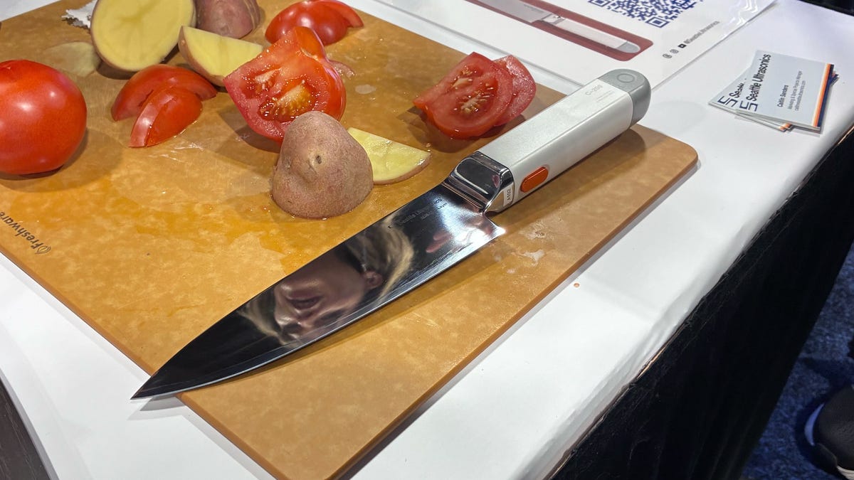 knife on cutting board with potatoes and tomatoes
