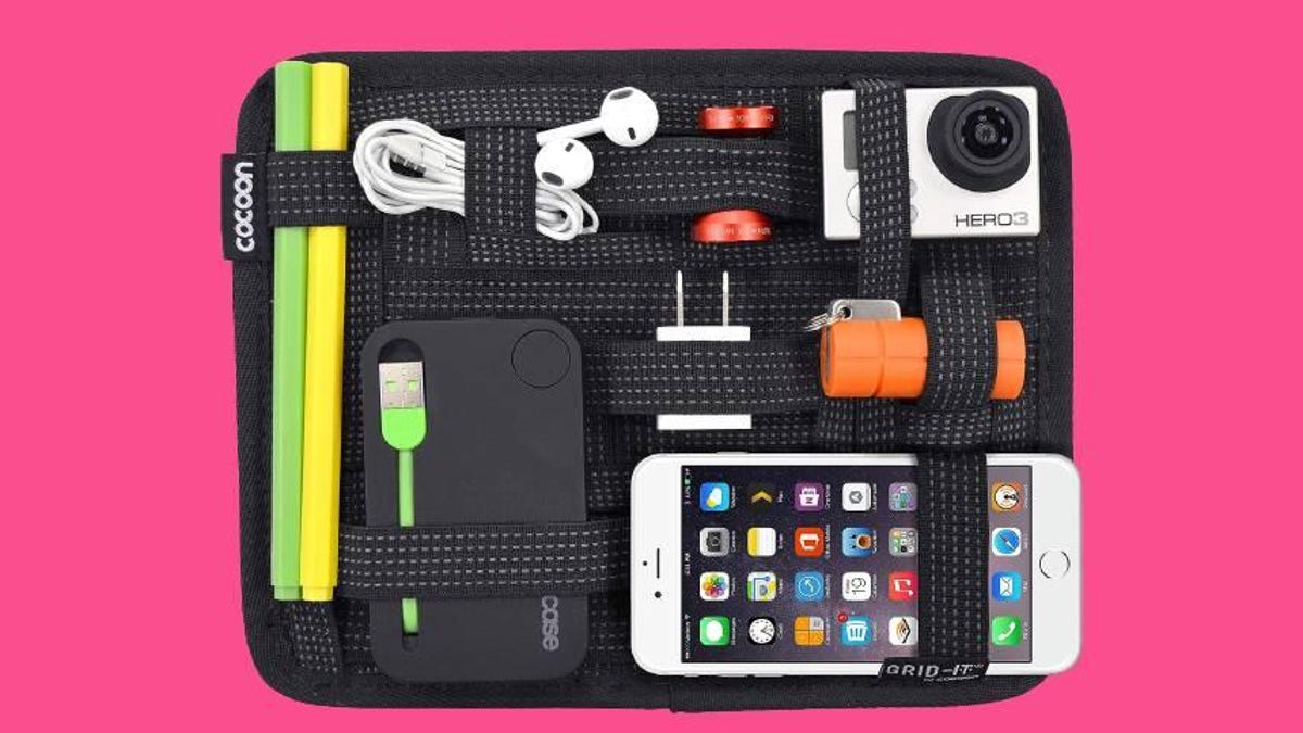 A Cocoon Grid-It organizer with an iPhone, Hero 2 digital camera, pens, chargers and headphones secured by elastic bands