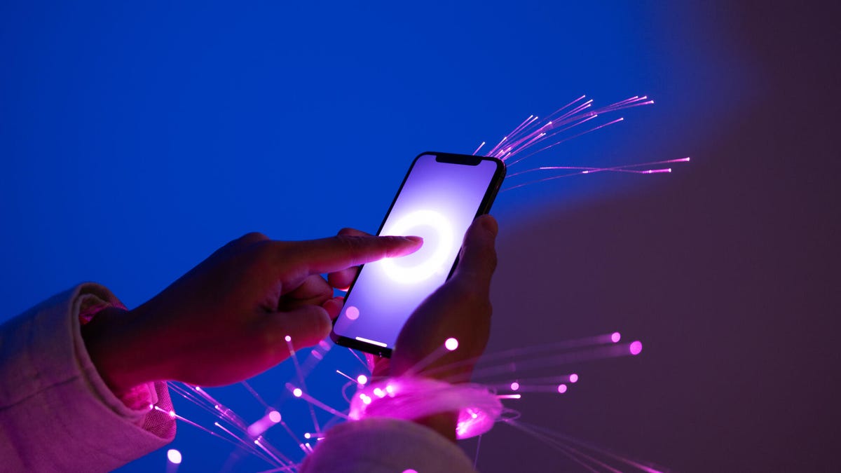 Smartphone seeming to shoot out neon streams representing AI