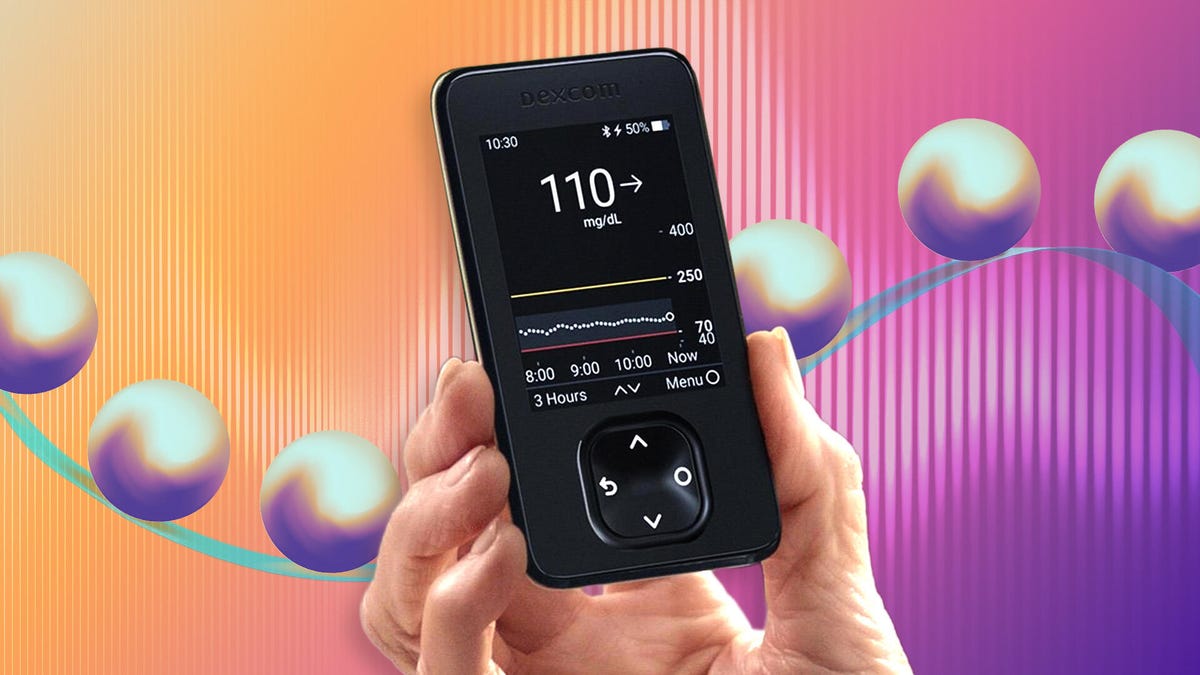 The Dexcom receiver held in a hand.