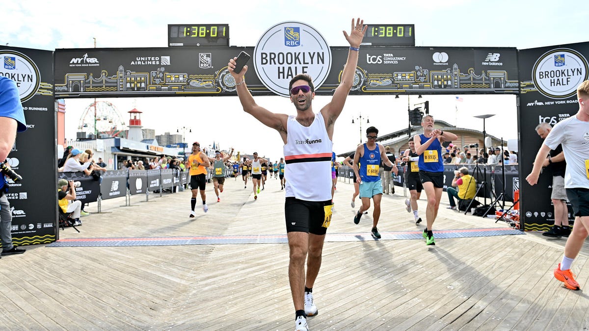 An image of a runner wearing a Runna singlet crossing the Brooklyn Half finish line.