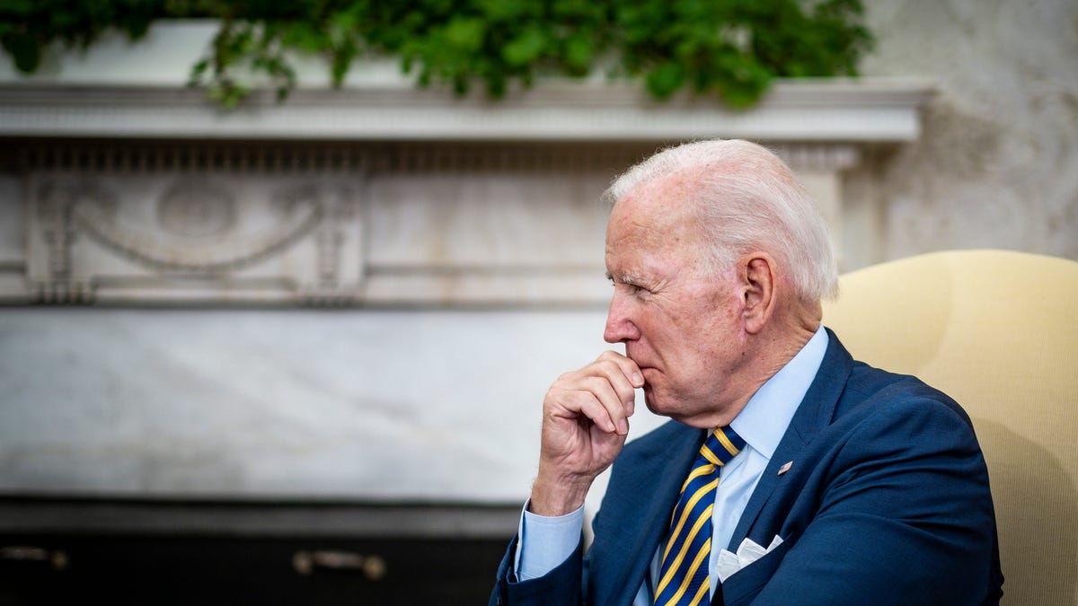 President Biden in a chair, listening and thinking