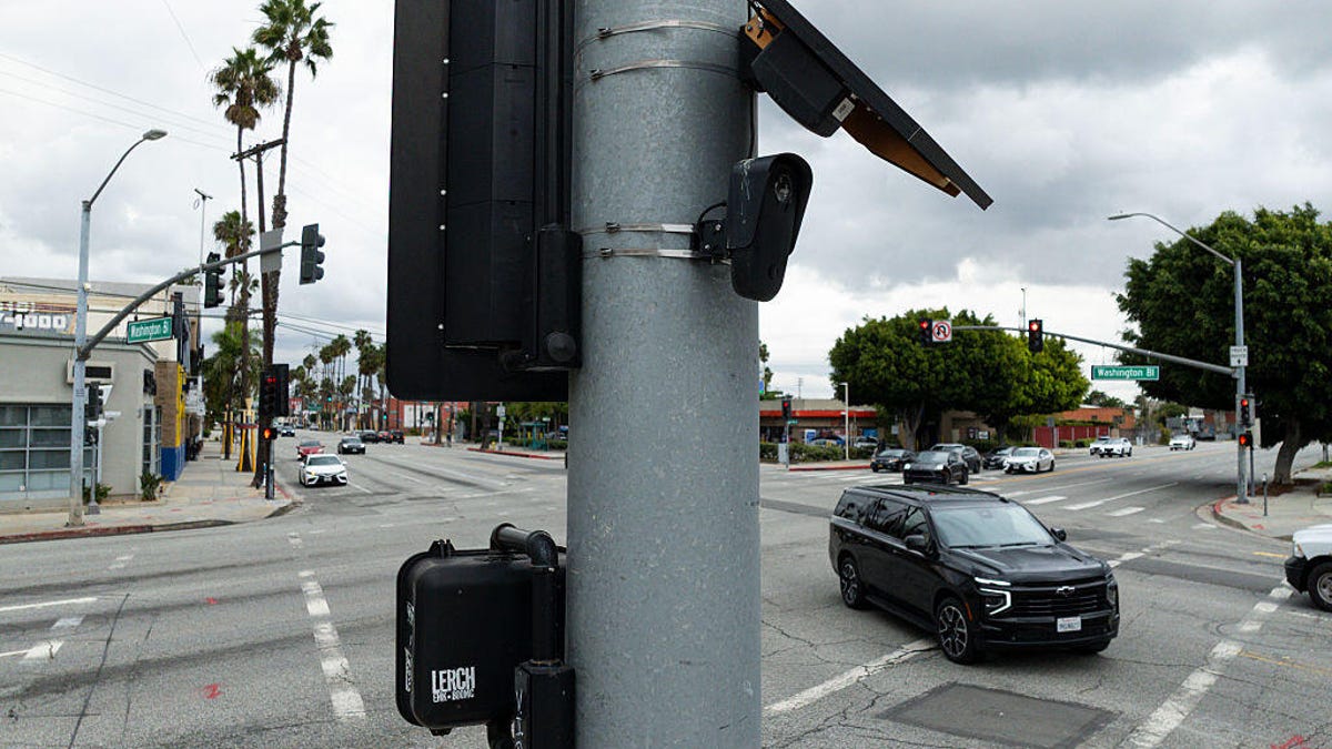 A license plate camera and solar panel at an intersection.