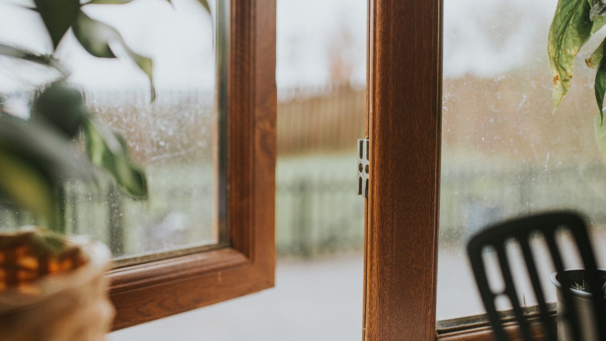 A home window left open while rain falls outside.