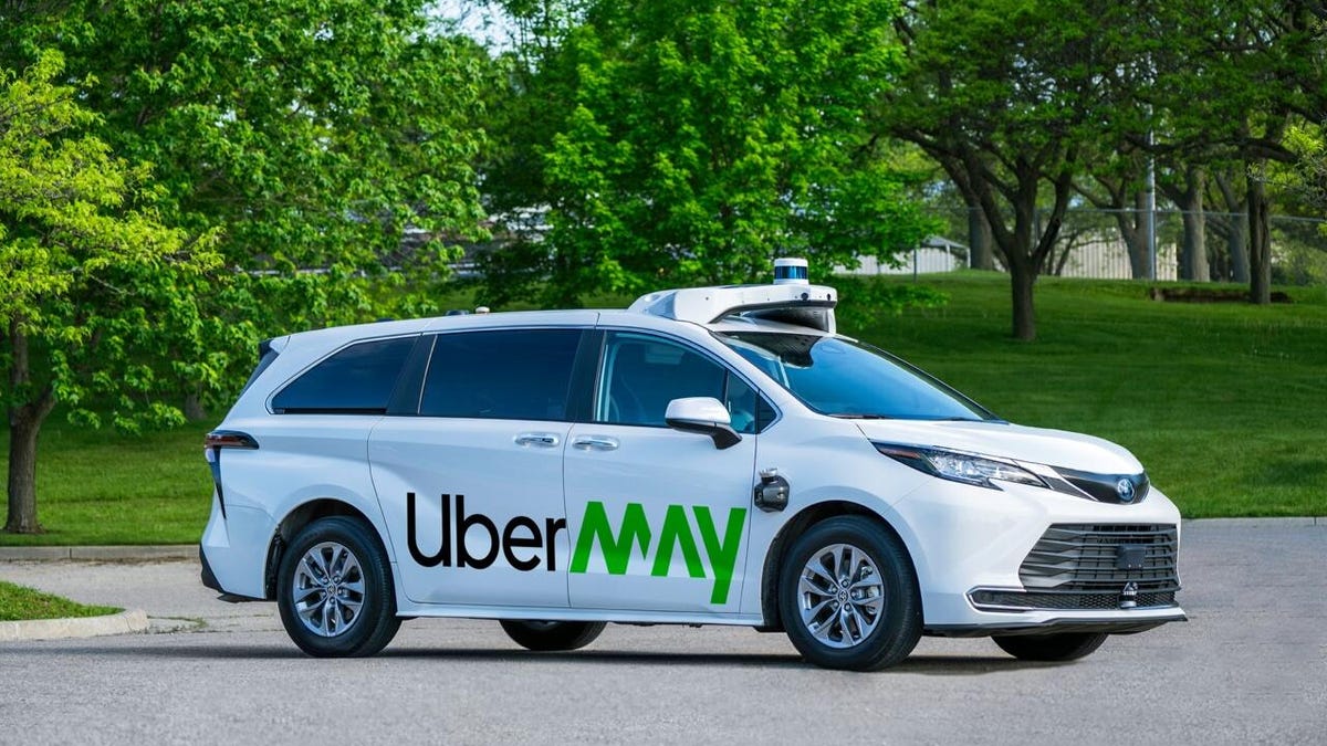 White Toyota Sienna with "Uber May" written on the side