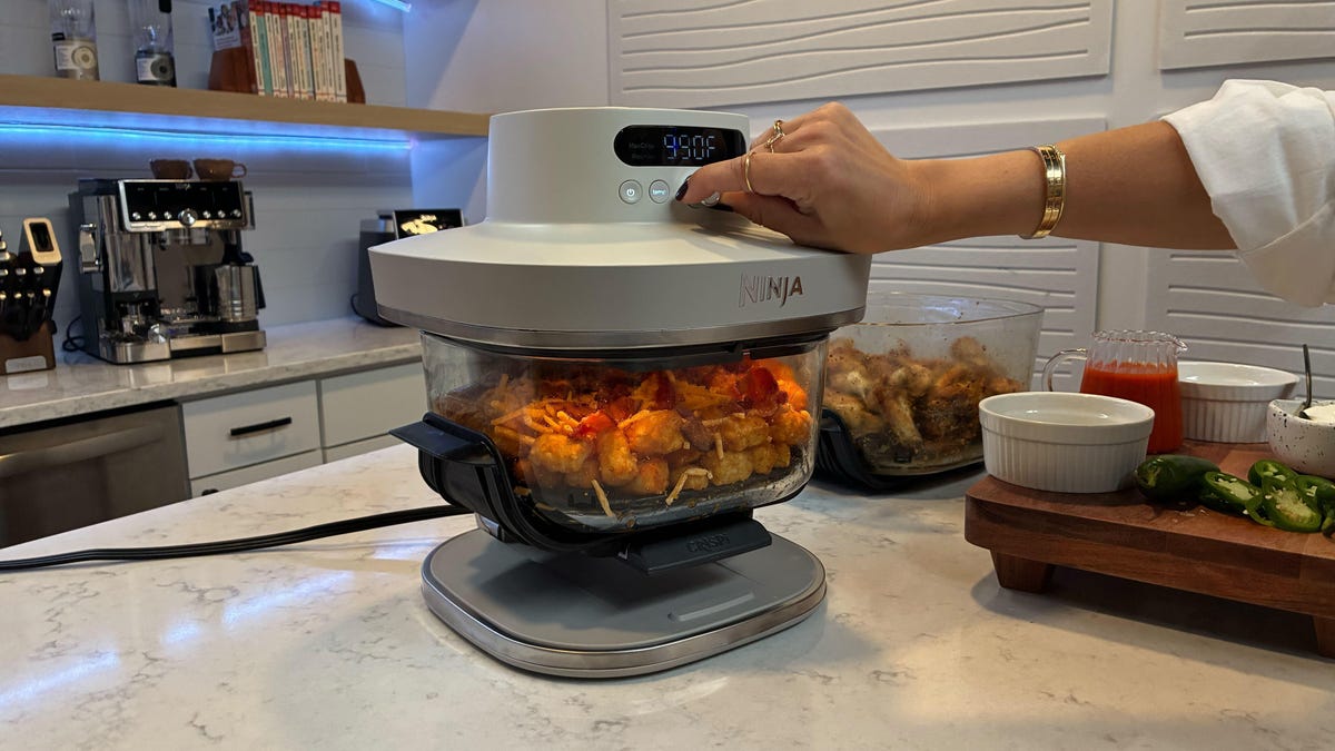 air fryer on a table with food in the backdrop.
