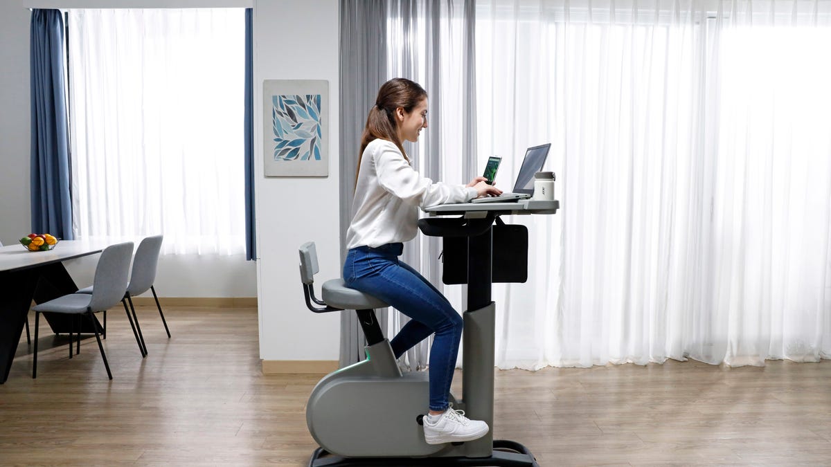 A woman rides the eKinekt BD 3 bike desk