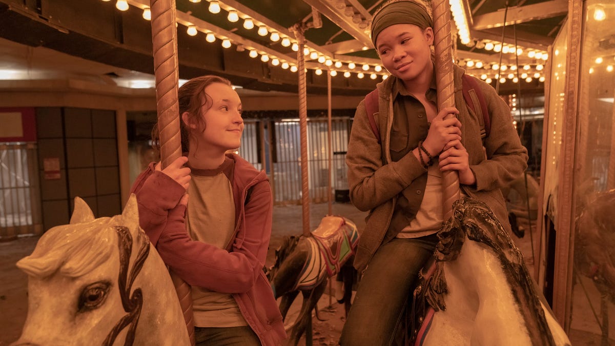 Ellie gives Riley a fond look as they ride a carousel in The Last of Us