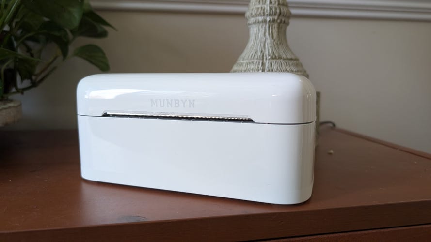 A white thermal printer on a brown desk