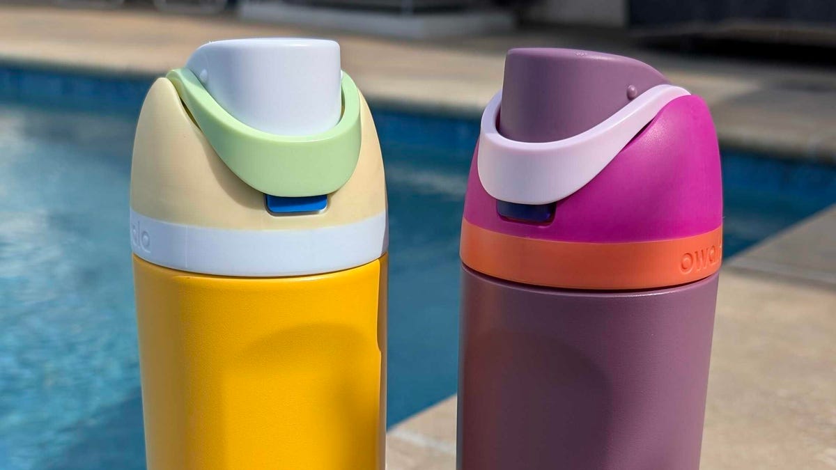 2 owala water bottles by the pool with fun yellow, pink and purple colors