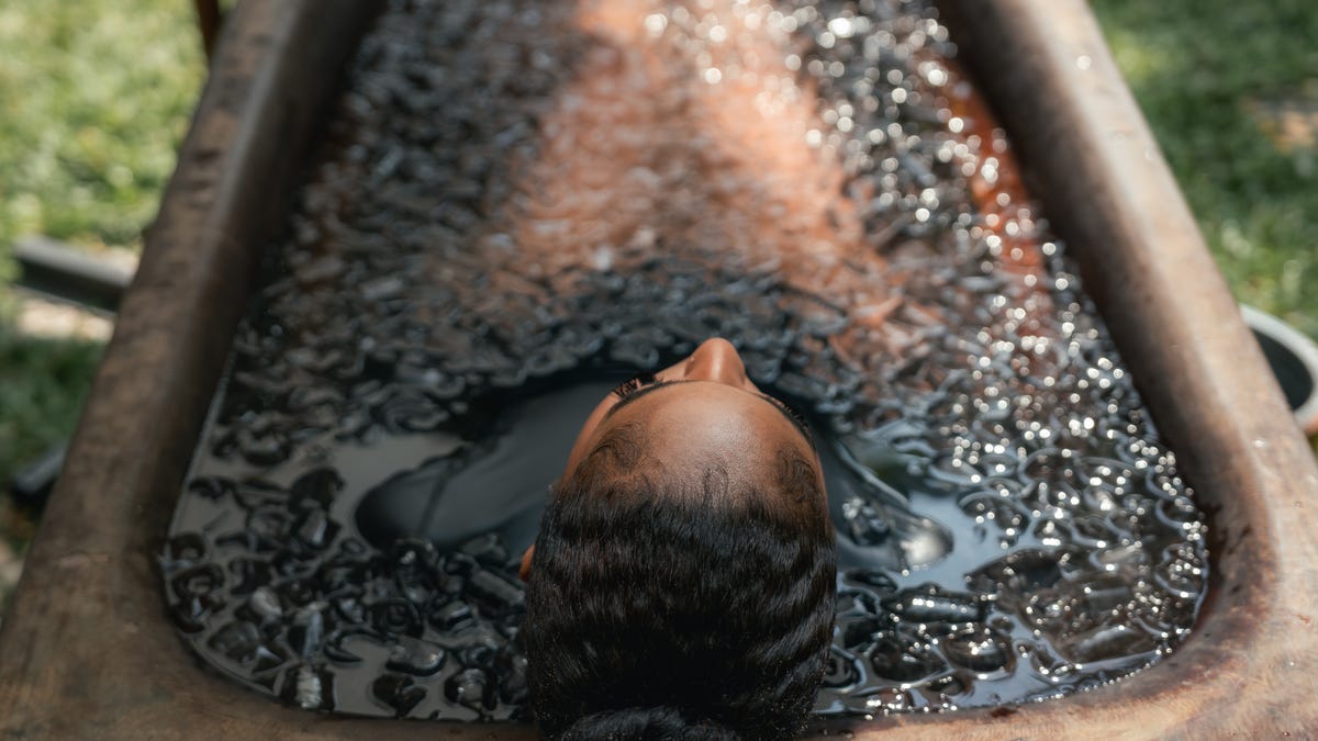 Woman taking an ice bath in a cold plunge tub