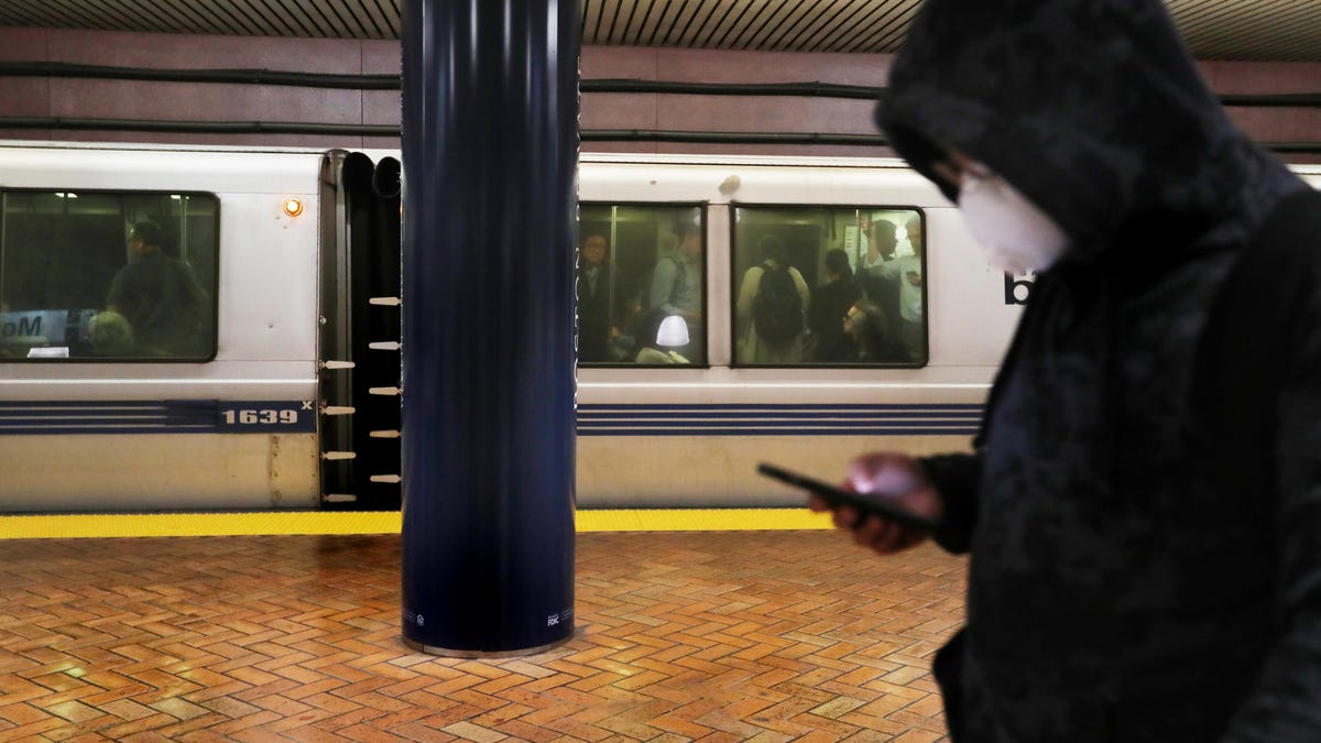 A commuter at a Bay Area Rapid Transit station wears a mask to protect against the coronavirus.