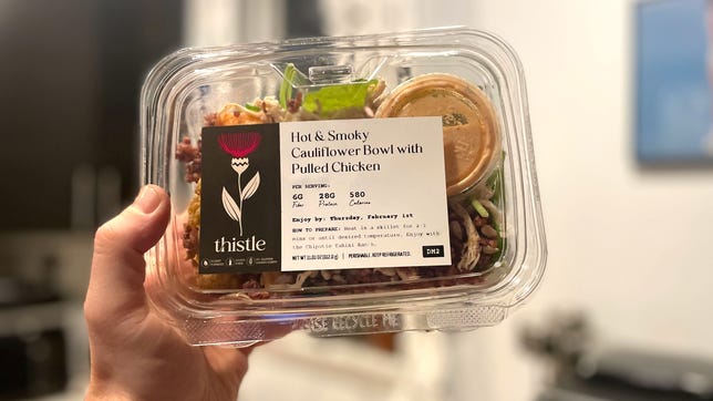 Hand holding thistle salad