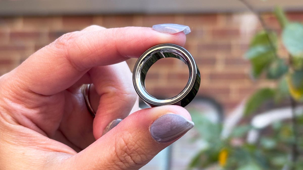 The Oura Ring 4 being held up outside in a park