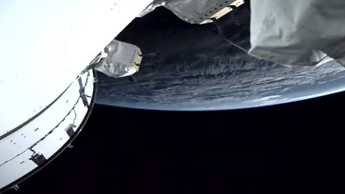 Part of the Orion spacecraft pops out in white in a screenshot view showing Earth in the background.