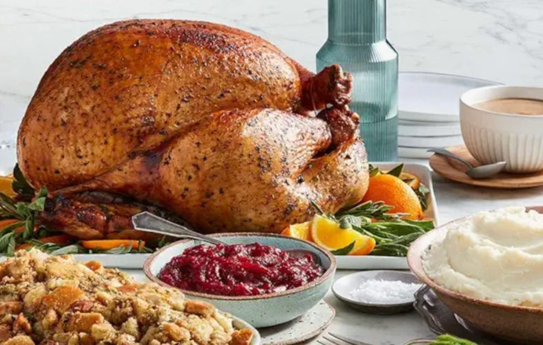 a turkey on a table with stuffing and cranberry sauce