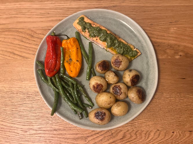 salmon and vegetables on a green plate that is sitting on a table