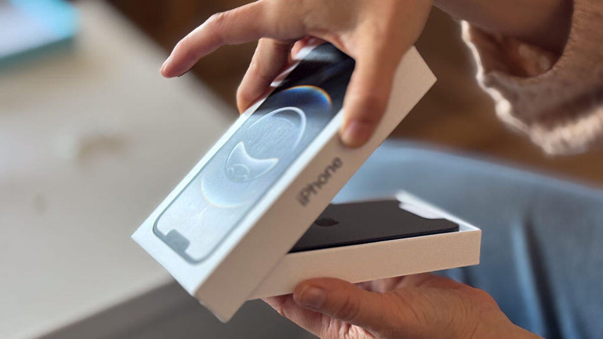 Hands open an iPhone box.