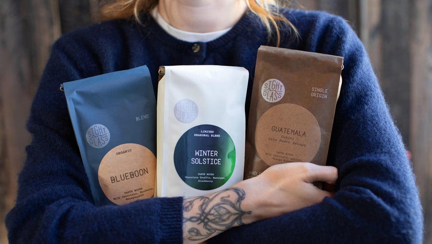 person holding bags of coffee