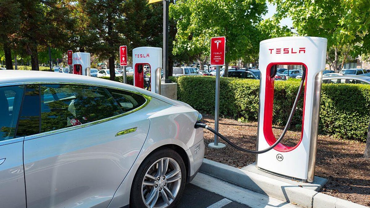 Photo showing a Tesla car hooked up to an electric-vehicle charger.