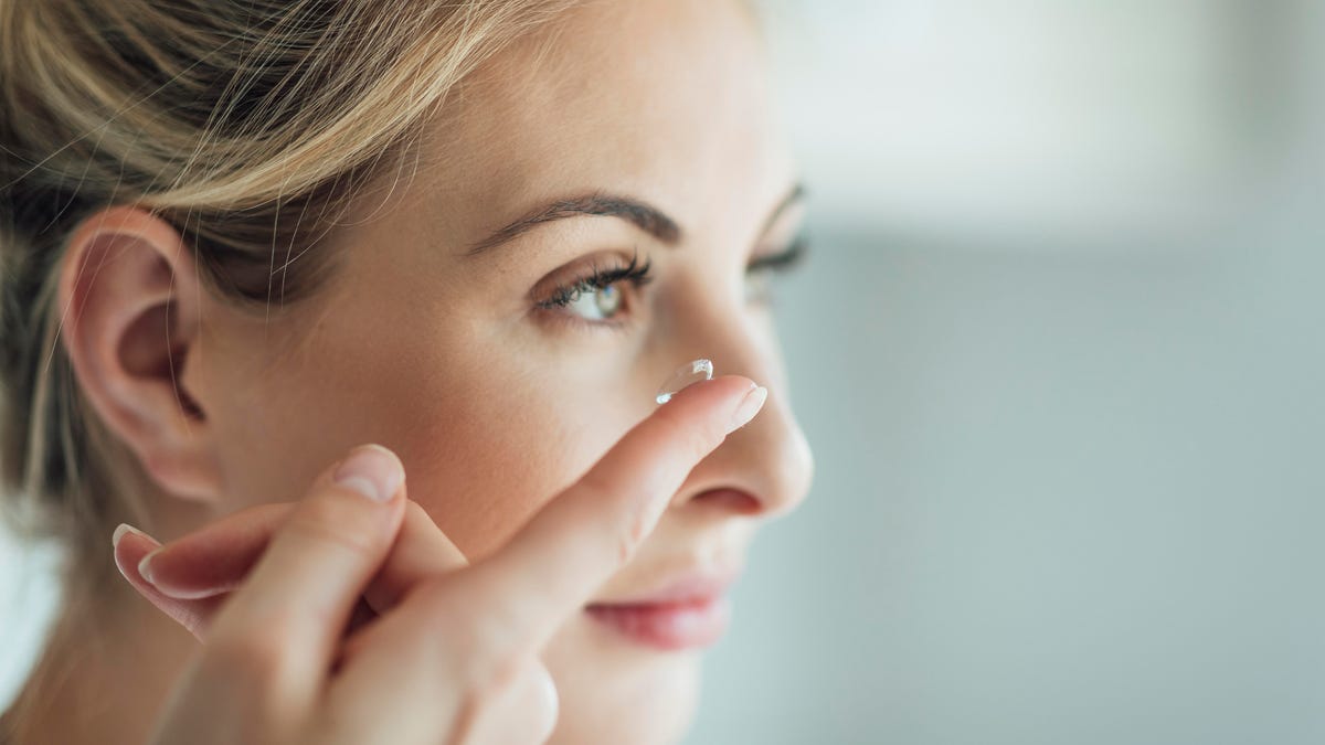 Woman putting in contact lenses