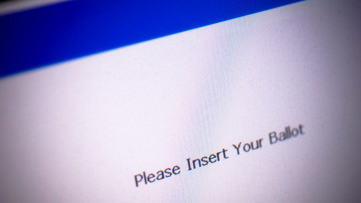 Voting machine screen reads "Please insert your ballot."