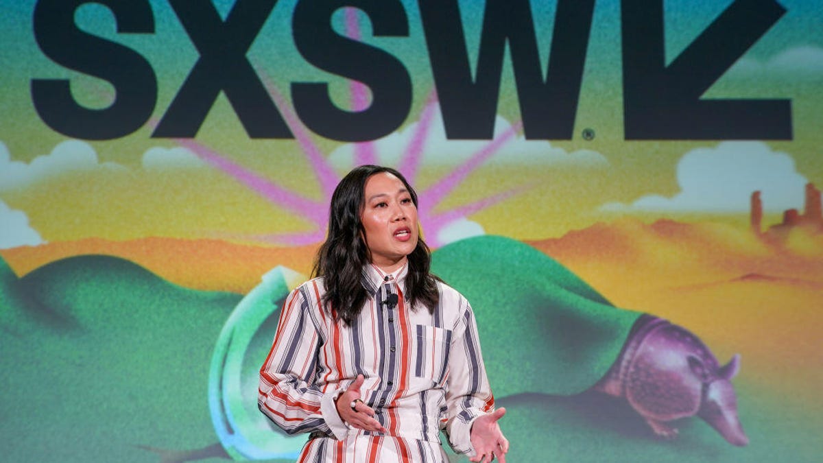 A woman in a striped dress stands in front of a background that says "SXSW"