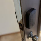 A Yale Assure Lock 2 keypad on an open brown door.