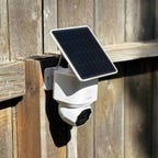 A Eufy SoloCam with solar panel on a fence in the sunlight.
