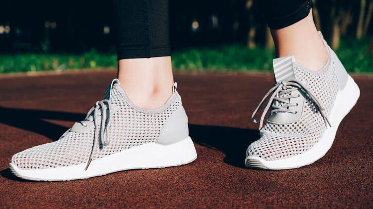Person wearing gray sneakers on a track.