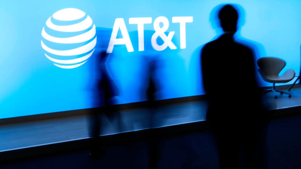 People walking past an AT&T sign