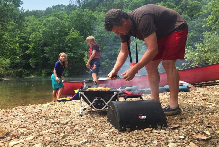 man tending charcoal grill