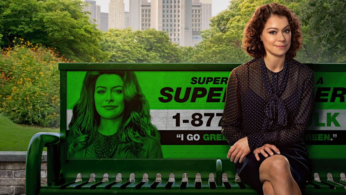 Tatiana Maslany plays Jen Walters, a lawyer sitting on a bench next to an advert showing her green superhero alter ego She-Hulk.