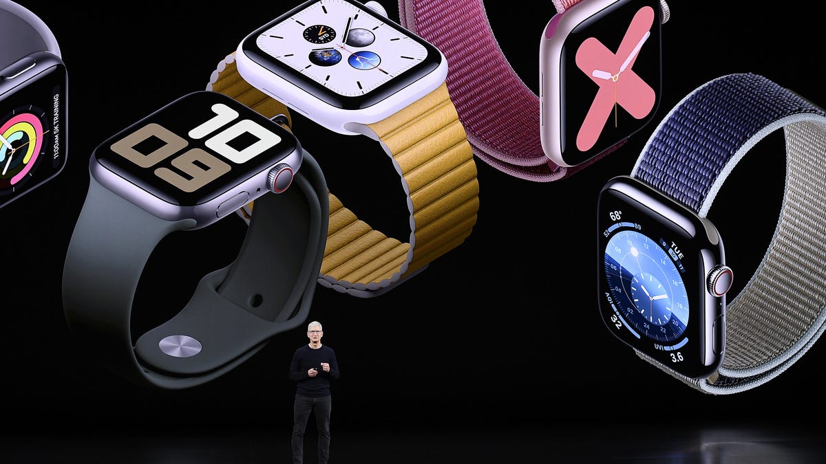 Tim Cook on stage talking in front of a black screen with Apple Watches displayed