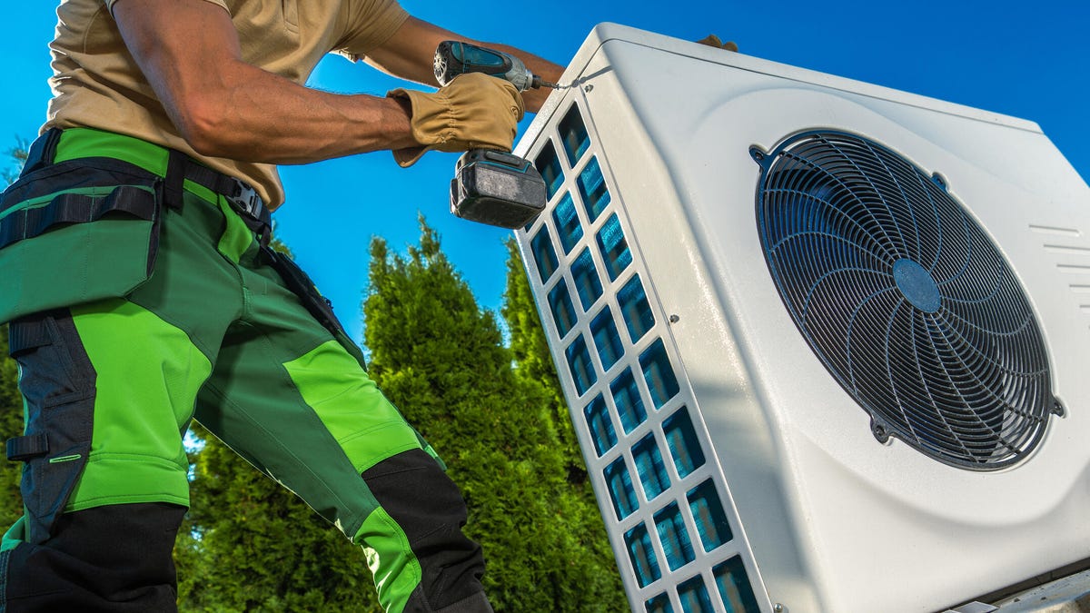 A technician installs a heat pump.