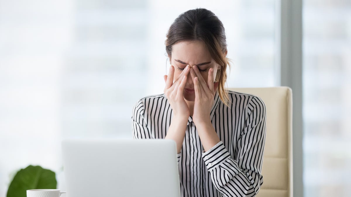 Tired woman massaging eyes.