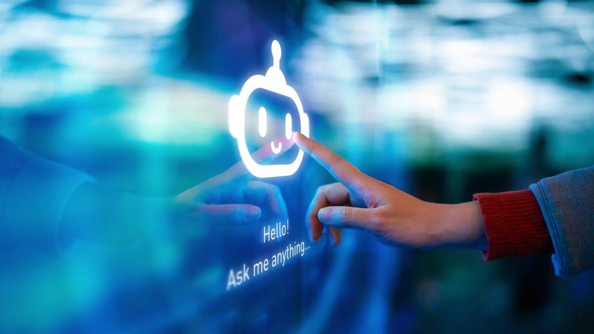 A hand touches a chatbot icon on a large blue screen.