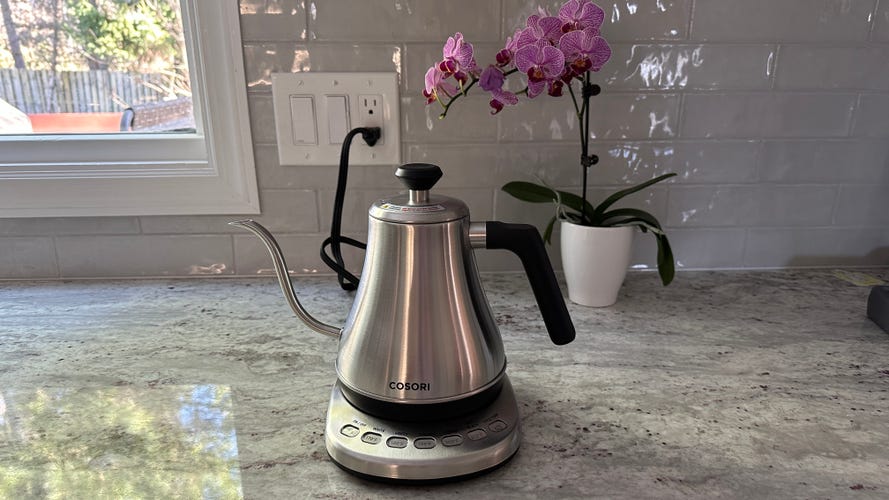 The Cosori Electric Gooseneck Kettle sitting on a granite kitchen countertop.