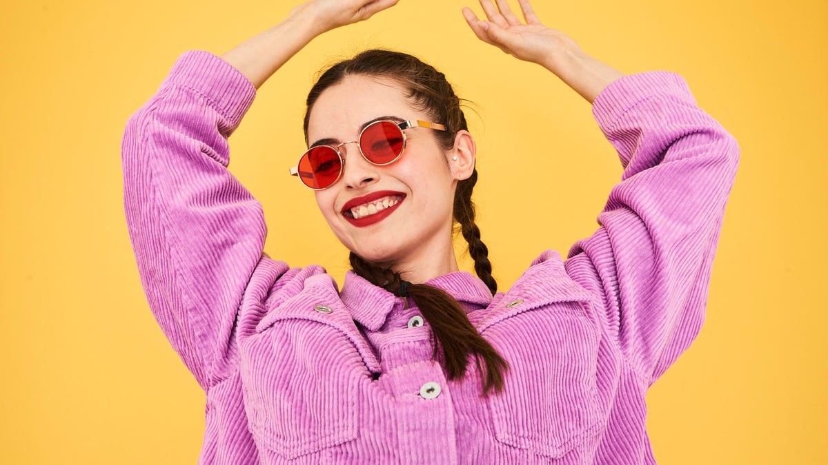 Woman in front of colorful background looking happy.