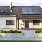 A home with rooftop solar panels and a back up battery.
