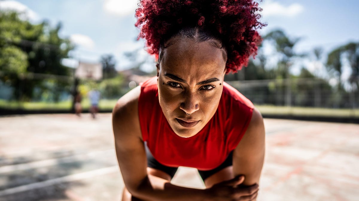 A tired athlete bends over and stares with strength