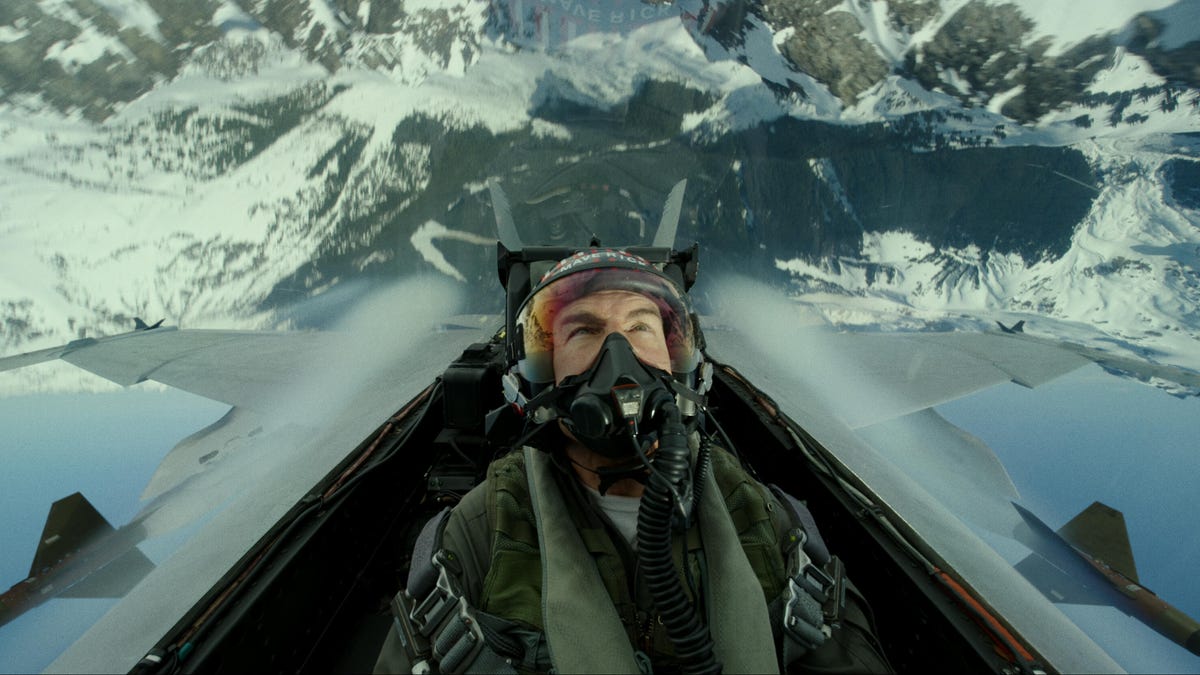 Tom Cruise, in Top Gun: Maverick, flies upside-down in a jet over snowy mountains