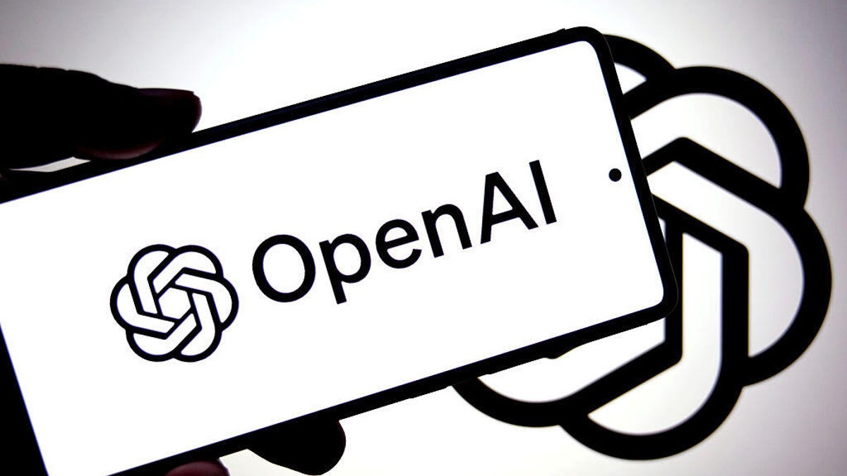 A hand holds a phone with the OpenAI logo on it.