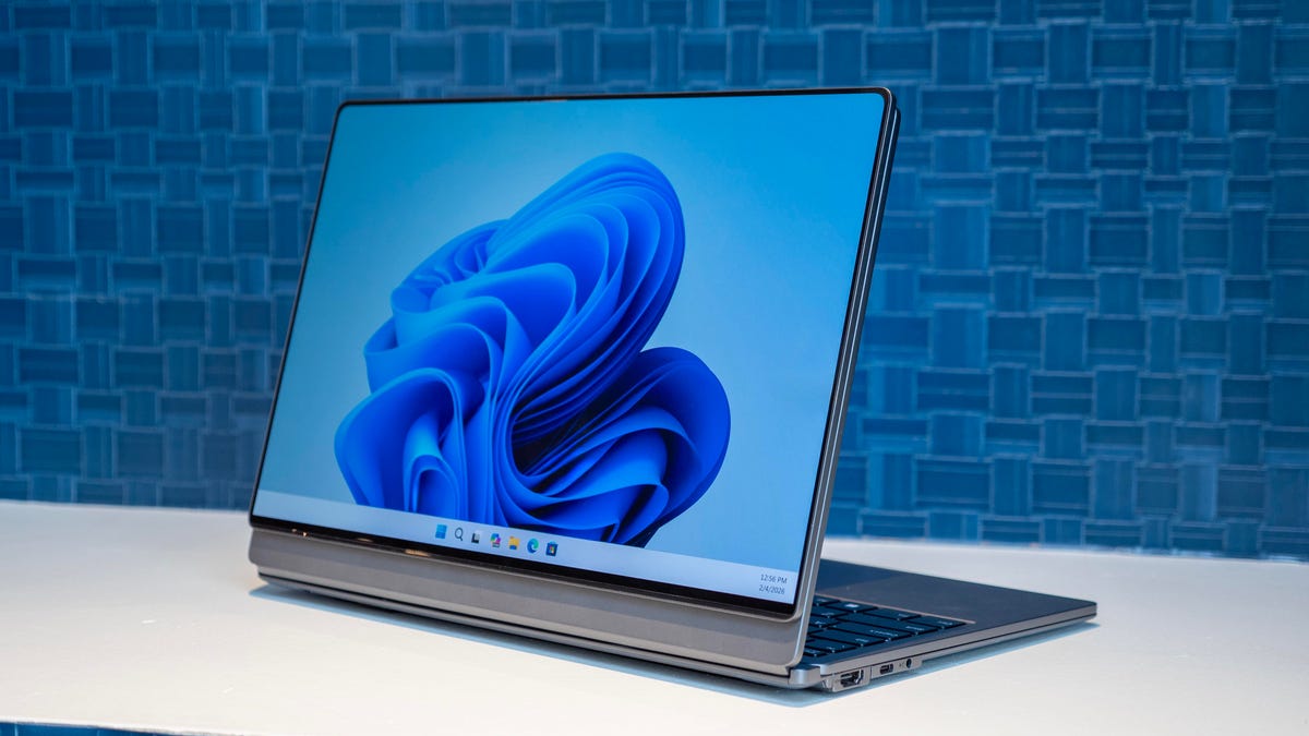 Lenovo ThinkBook Modular AI PC Concept on a white table in front of a blue wall. The removable secondary display is attached facing away from the keyboard.